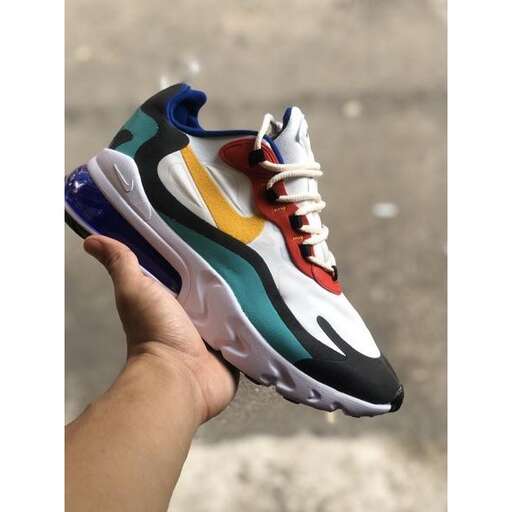 a hand holding a shoe that has been painted in different colors.