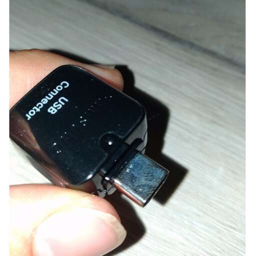 a person holding a battery with a plug in it.
