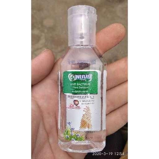 a hand holding a bottle of liquid.