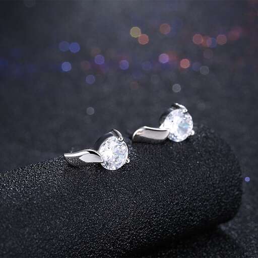 a pair of diamond earrings, by person.