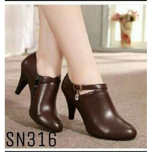 a pair of brown leather shoes with a bow