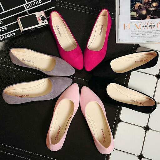 a pair of pink shoes sitting on top of a black table.