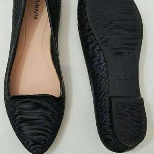 a pair of black shoes with a pink sole.