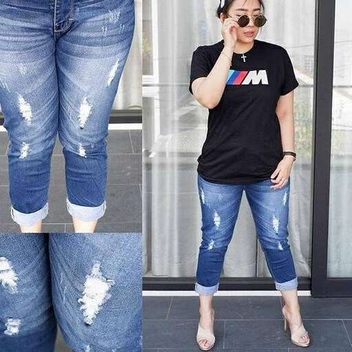 a woman wearing ripped jeans and a t - shirt.