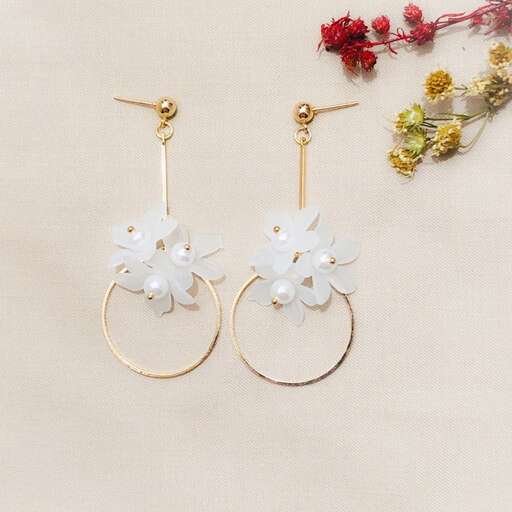 a pair of earrings with flowers and leaves