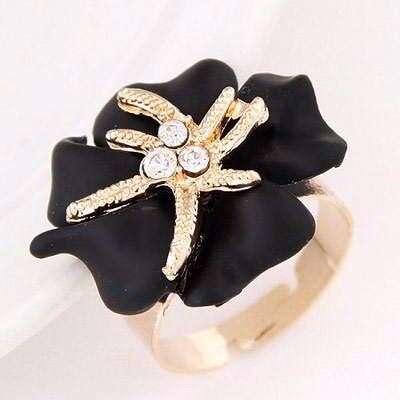 a black and gold ring with a diamond ring in the center.