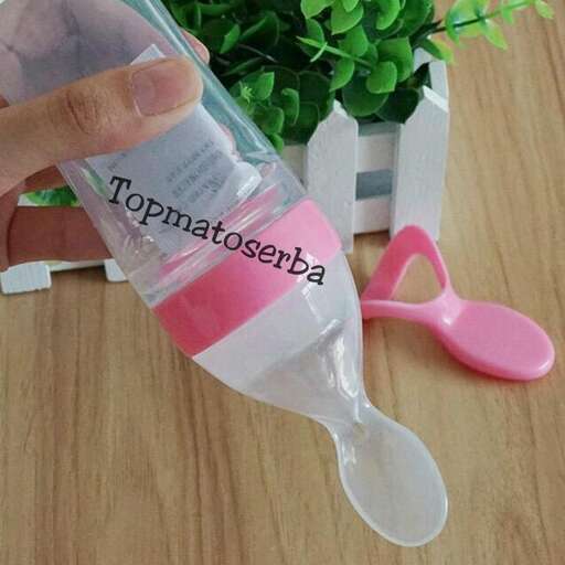 a plastic bottle with a pink handle and a white spoon.