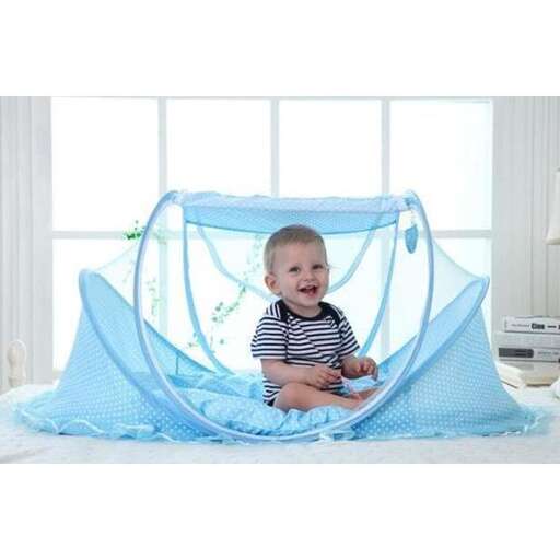 a baby sitting in a bed with a blue blanket.