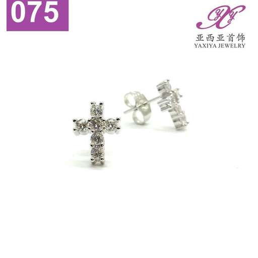a sterling silver cross with a cross on the front and a small heart.