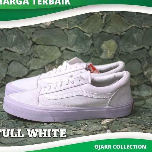 a white sneaker with a red spot on the bottom.