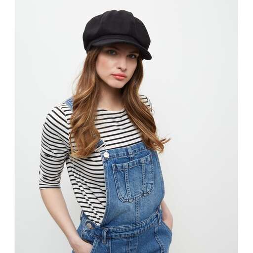 a woman in a hat and denim overalls