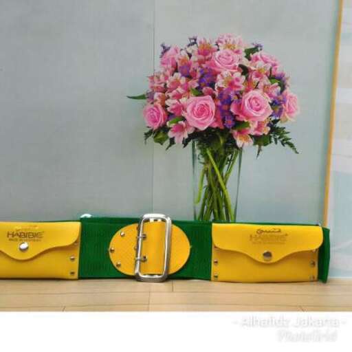 a green and yellow case with a flower arrangement in it.