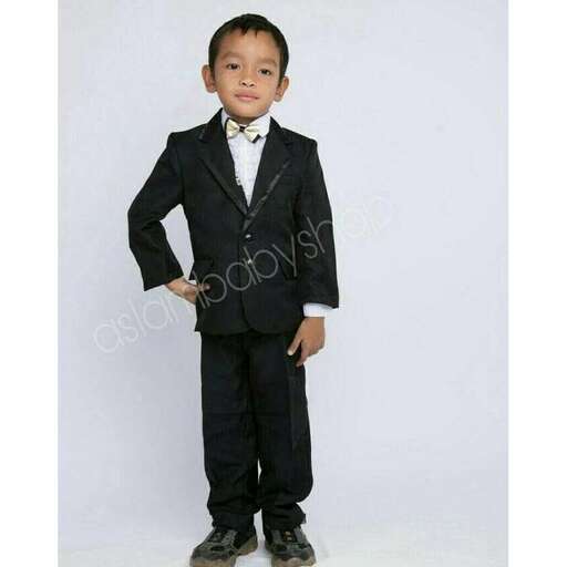 a young boy dressed up in a tuxedo.