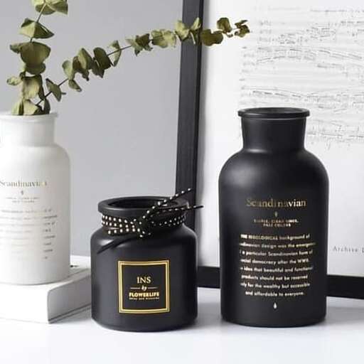 a desk with a bottle and a vase on it.