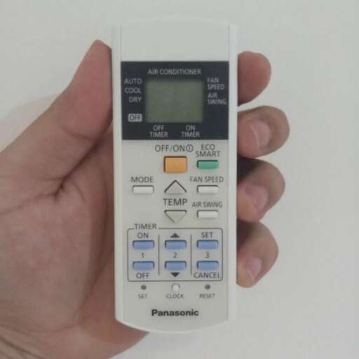 a person holding a remote control in their hand.