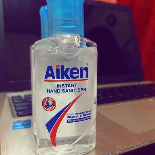 a bottle of hand sanitizer sitting on a desk.