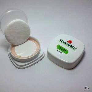 a white powder and a pink brush in a white container.