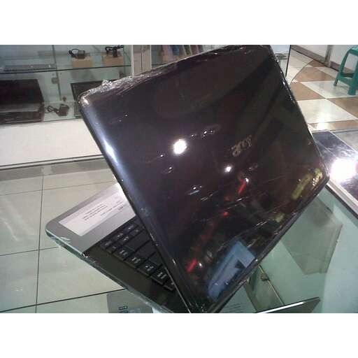 a laptop computer sitting on a glass table.