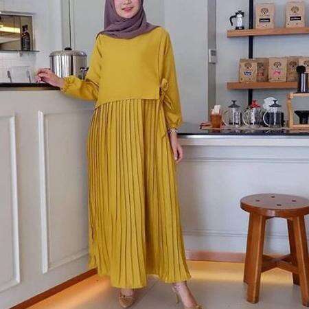 a woman in a yellow dress standing in a kitchen.