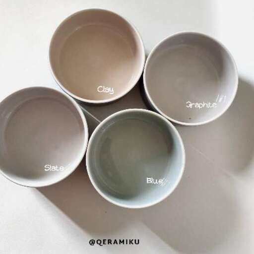 a set of three bowls with different colored handles.