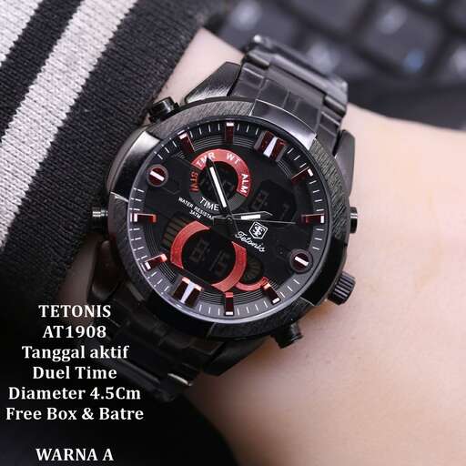 a watch with a black face and red dial on the wrist.