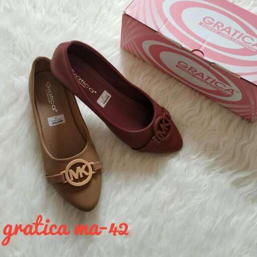 a pair of brown shoes sitting on a white rug.