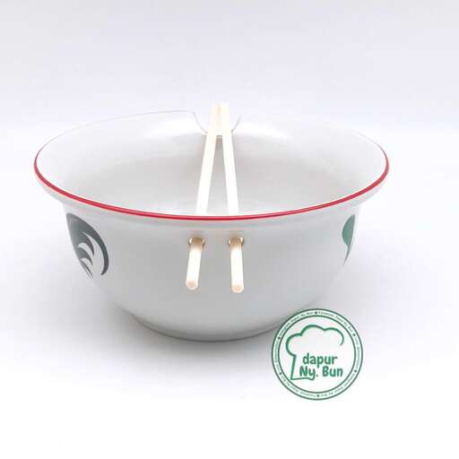 a bowl of soup with chopsticks