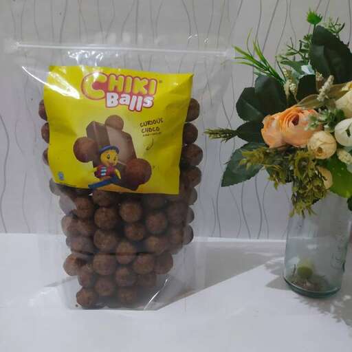 a table with a vase of nuts and a vase of flowers.