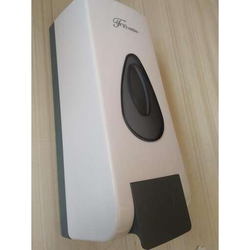 a white and black speaker on a wooden table.