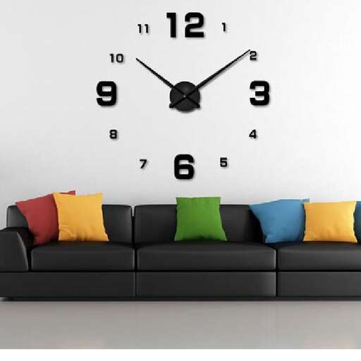a black couch with colorful pillows and a clock on the wall.