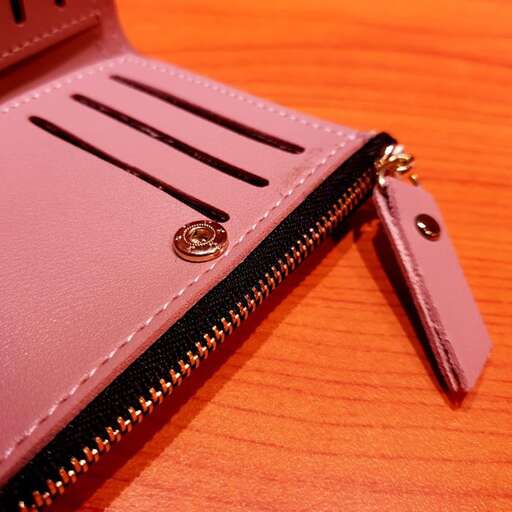 a small wallet with a zipper on a wooden table.