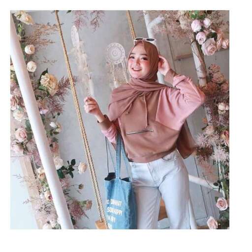 a woman in a pink shirt holding a bag