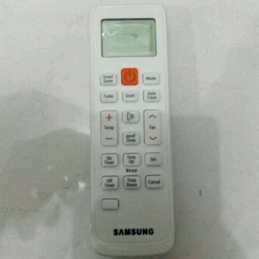 a white remote control with buttons on the front.