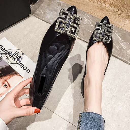 a woman's feet with a pair of black shoes.