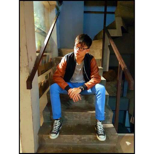 a boy sitting on the stairs of a building.