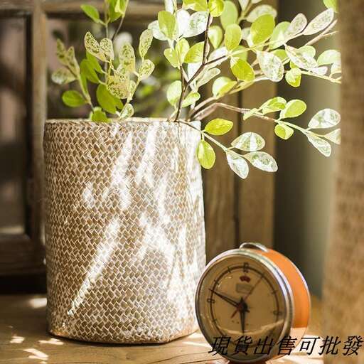a clock sitting on a table next to a plant.