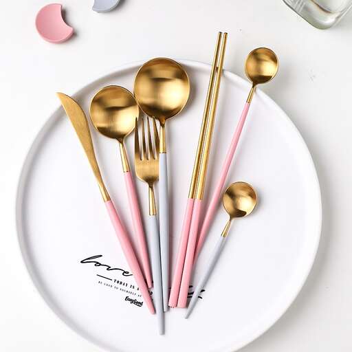 a set of gold spoons on a plate with gold spoons.