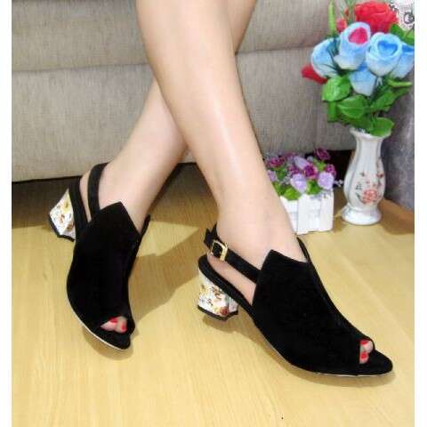 a woman's feet in black sandals with flowers.