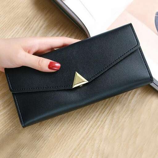 a woman's hand holding a small wallet.