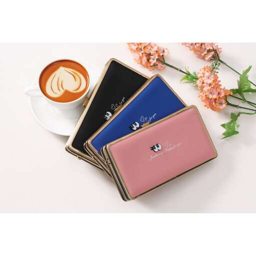 a pink wallet sitting on top of a white table.