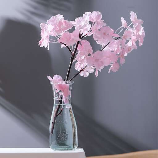 a vase with pink flowers in it on a table.