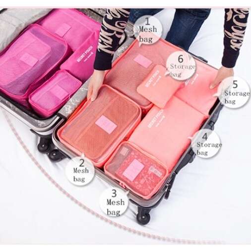 a woman is standing next to a pink suitcase.