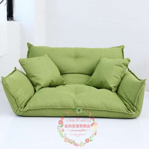a green sofa with a floral pattern on the seat.