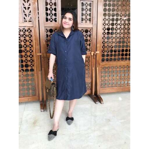 a woman in a dress standing in front of a door.