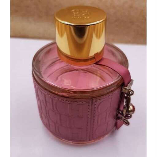a perfume bottle sitting on top of a white surface.
