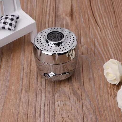 a small metal flower holder with a small white flower inside.