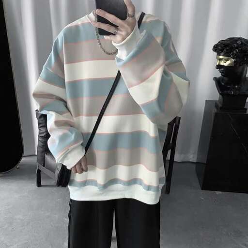 a person wearing a striped sweater and black pants.