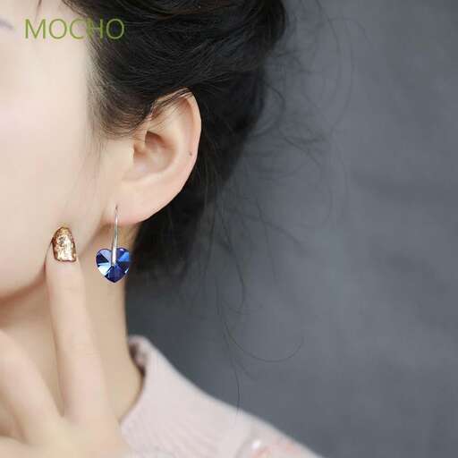 a pair of earrings with a blue and gold butterfly on the ear.