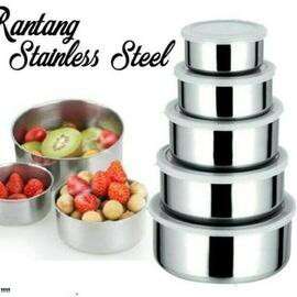 a metal bowl with a variety of fruits in it.
