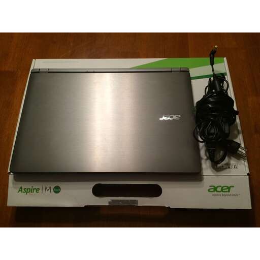 a laptop computer sitting on top of a cardboard box.